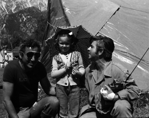 1976. Une frutine e doi portuâi de C.U.L.M.V., la "Compagnia Unica dei Lavoratori Merci Varie" dal puart di Gjenue, che a fasevin part di une des scuadris di socors intervignudis a Dartigne dopo dal taramot.